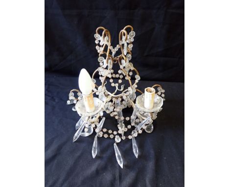 A 20TH CENTURY GILT METAL ELECTRIC WALL LIGHT fitted two sconces and hung with prismatic drops, 29cm high x 37cm wide x 20cm 