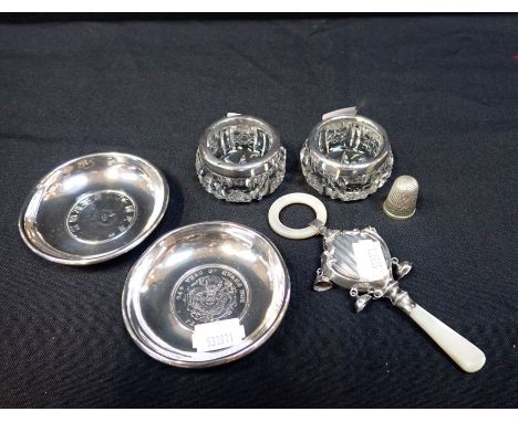 A PAIR OF SILVER MOUNTED SALTS with a silver thimble, a white metal baby's rattle and two Far Eastern white metal dishes
