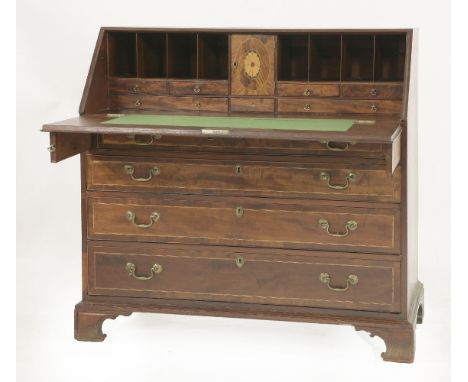 A George III mahogany and inlaid bureau, the slope front enclosing an interior centred with a cupboard and flanked with pigeo