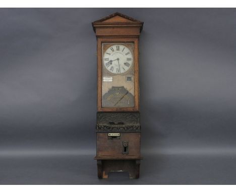 An early 20th century National Time Recorder, oak cased clocking in machine, of architectural design and cast iron detailing,