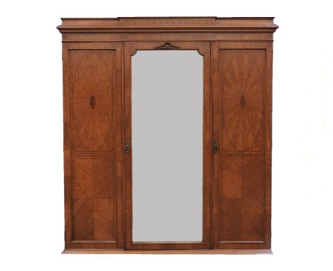 An Edwardian satinwood crossbanded and inlaid triple wardrobe, by Shapland and Petter, Barnstaple, the central mirrored door 