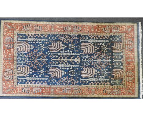 A large Indo Chakhari carpet, the blue ground with stylized garden design, within a multiple banded border, 361cm x 269cm