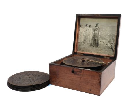 A late 19th century and walnut cased Kalliope table top musical disc player, fitted steel comb movement, with winding handle 