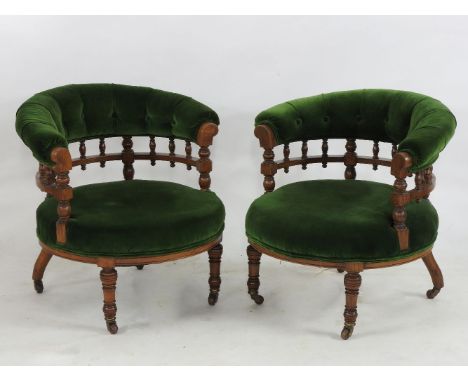 A pair of late Victorian horseshoe backed tub chairs, overstuffed upholstered seats and ring turned legs, each 70cm wide, a p