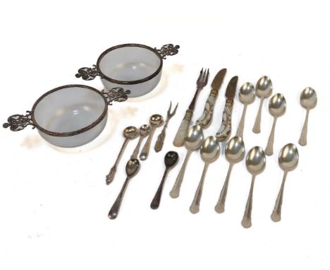 A pair of silver mounted twin handled glass bowls, a collection of serving flatware, and nine teaspoons
