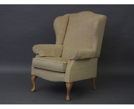 A contemporary wingback armchair, with short commode legs, 80cm wide