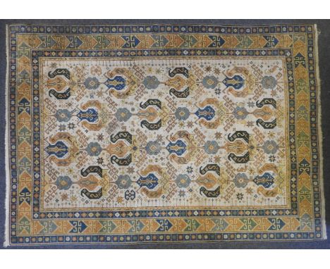 A cream ground Caucasian carpet, the central field with latch hook and gul design, 277cm x 208cm