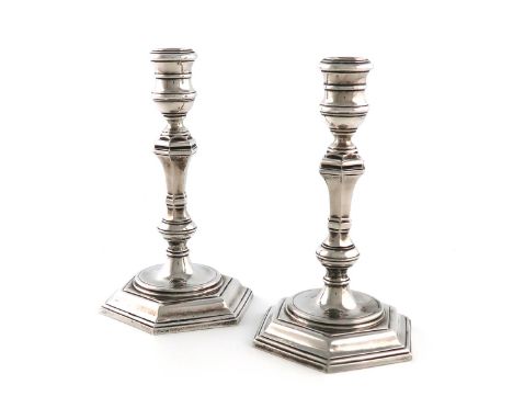 A pair of cast silver candlesticks, by R. Comyns, London 1956, in the George I manner, hexagonal baluster stems, spool-shaped