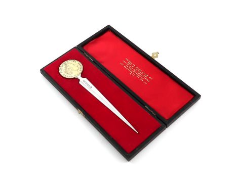 By Stuart Devlin, a modern commemorative silver parcel-gilt letter knife, London 1977, tapering form, the terminal set with a