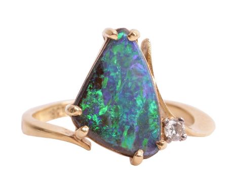 A boulder opal dress ring, claw-set with a triangular polished boulder opal, displaying vibrant play-of-colour mainly ranging