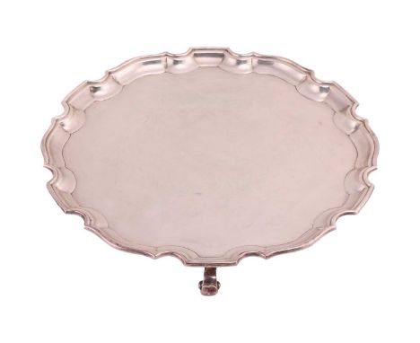 A silver pie crust edge salver by Adie Brothers, Birmingham 1929, with plain centred supported on three scroll feet, hallmark