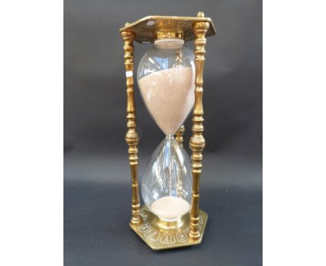 A giant brass and glass one hour egg timer with zodiac decoration, 55cm tall