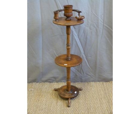 An Edwardian oak two tier pipe or smoker's stand