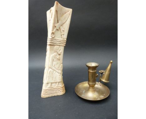 A carved African bone and a brass chamber stick 