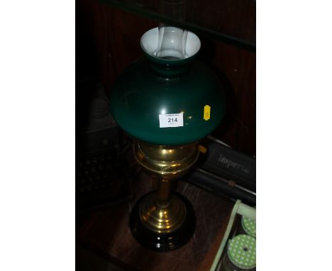 A VINTAGE OIL LAMP WITH GREEN GLASS SHADE