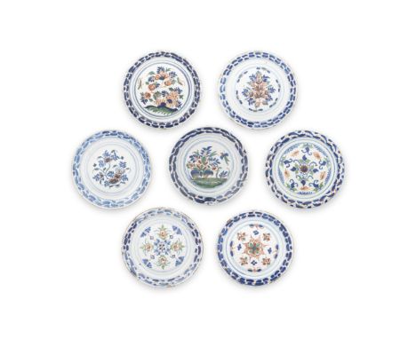 Seven interesting English delftware plates, circa 1710-30London or possibly Bristol, with formal floral designs in red, green