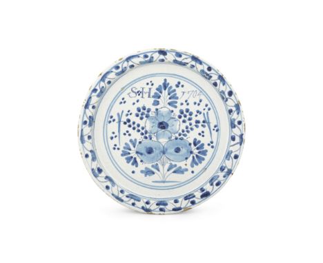 An English delftware inscribed plate, dated 1704Brislington or London, of flat profile, painted in two tones of blue with for