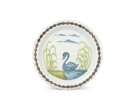 A London delftware plate, circa 1740-50Of 'Farmyard' type, painted in blue, green and manganese with a swan swimming by a gra