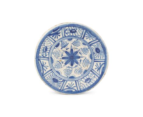 An early Southwark delftware charger, circa 1630-40Boldly painted in blue with a central daisy-like floral starburst within a