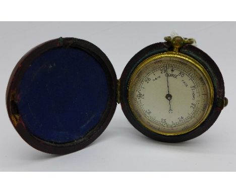 A brass pocket barometer in a leather case