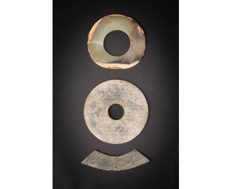 THREE CHINESE ARCHAIC JADES NEOLITHIC AND LATER Comprising: a bi disc incised on both sides with C-scrolls, the stone is part