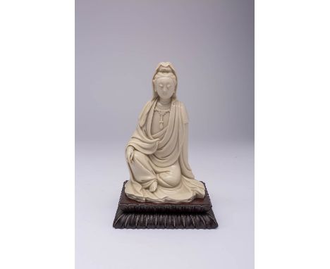 A CHINESE BLANC DE CHINE SEATED FIGURE OF WATER-MOON GUANYIN 17TH/ EARLY 18TH CENTURY The Goddess of Compassion sits wearing 