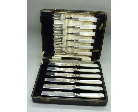 A set of six mother of pearl handled knives and forks, with silver ferrules