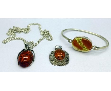 A .925 silver and amber pendant, a .925 silver and amber pendant on a sterling silver chain and a white metal bangle