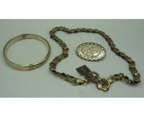 A silver bangle, a Victorian silver brooch, Birmingham 1882, and a Victorian white metal necklet