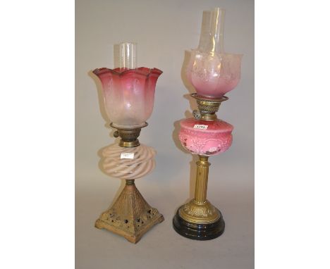 Victorian brass and pink opaque glass oil lamp with matching shade and chimney together with another similarBottom opening of