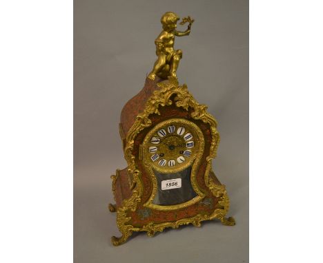 19th Century red stained tortoiseshell buhl work mantel clock with figure surmount, the gilded dial with ceramic numerals, th