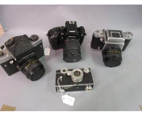 Pentacon Six TL SLR camera, a Nikon F4 SLR camera and a similar Russian camera together with a mid 20th Century roll film cam