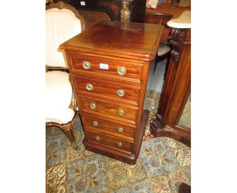 Pair of mahogany slim chests of five drawers with circular brass ring handles, raised on plinth bases, 33.5ins high x 16.5ins