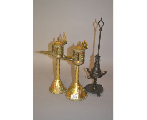Pair of oriental brass and copper mounted oil lamps together with another Middle Eastern bronzed metal oil lamp 