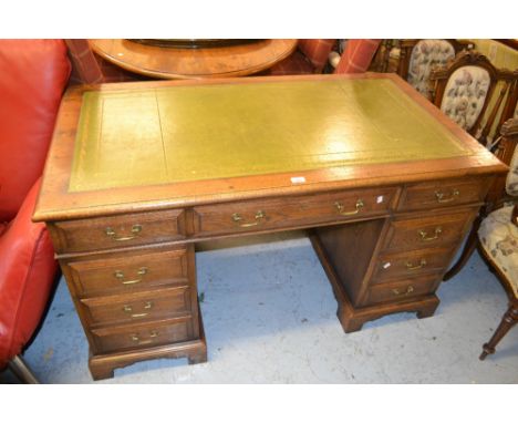 Cotswold oak pedestal desk, the green leather and gilt tooled top above an arrangement of nine drawers with brass swan neck h