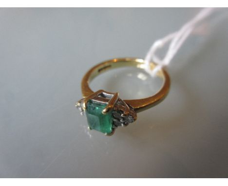 18ct Yellow gold ring set emerald flanked by six small diamonds 