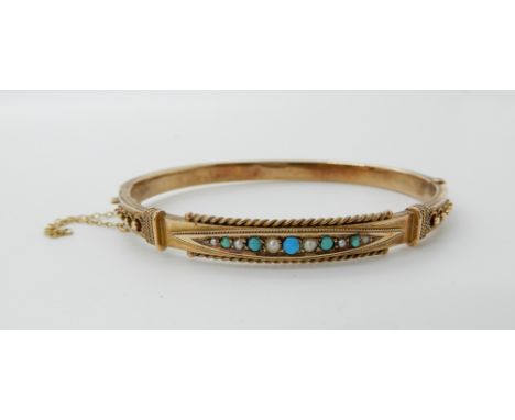 A 9ct gold turquoise and pearl Etruscan revival bangle, inner dimensions 5.9cm x 4.7cm, weight 7.4gms Condition Report: One c