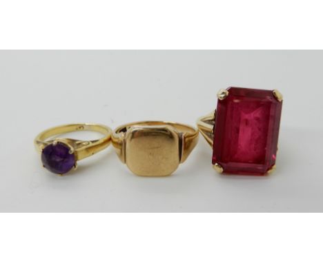 A bright yellow metal ring set with an amethyst size I1/2 (I for India), a 9ct gold large red paste gem set ring, size I1/2, 