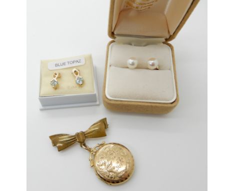 A 9ct back and front locket diameter 2.3cm, with attached gold plated bow brooch, a pair of blue topaz 9ct gold earrings, len