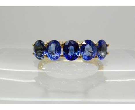 An 18ct gold five stone sapphire ring, size L1/2, weight 3.5gms Condition Report: Sapphires don 't match, banding visible in 