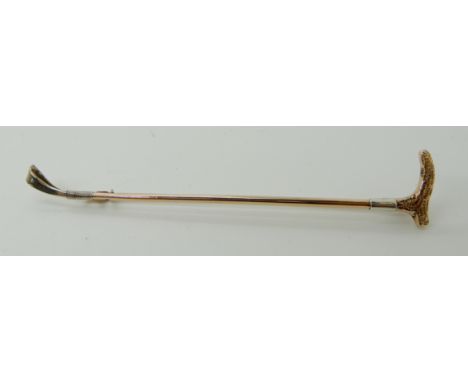 A 9ct white and rose gold riding crop brooch, length 9cm, weight 4.9gms Condition Report: light general wear.