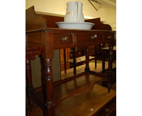 A Victorian mahogany three quarter gallery backed wash stand, having glazed ceramic jug and bowl, twin frieze drawers and rai