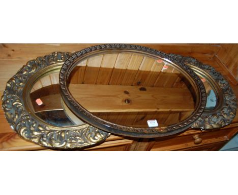 A pair of floral gilt decorated circular convex wall mirrors; together with a gilt oval wall mirror (3)