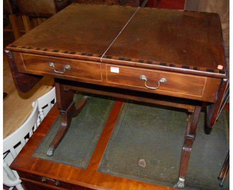 A 19th century mahogany Coromandel cross banded and satinwood strung sofa table, having twin frieze drawers and raised on ree