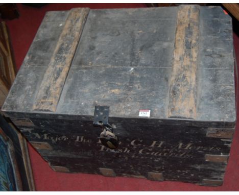 A circa 1900 painted pine and metal bound hinged top travelling trunk, having iron end carry handles, the front panel titled 