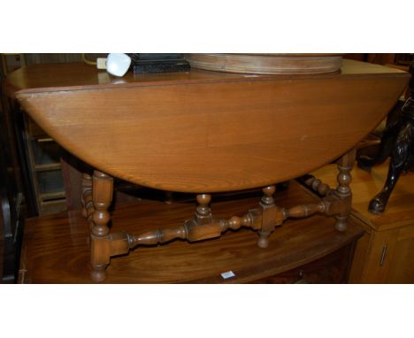 An Ercol mid elm drop flap coffee table having a gateleg action, width 104cm