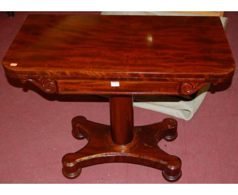 A Victorian mahogany round cornered fold over card table having a baize lined interior, revolving action, raised on gun barre