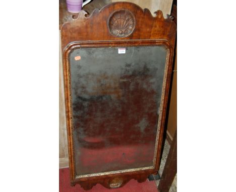 A 19th century figured walnut cushion framed wall mirror, in the George II taste, having central upper scallop shell and with