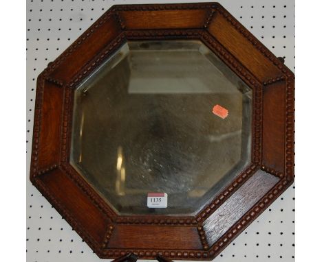 A 1920s beaded oak octagonal wall mirror, dia. 44cm 