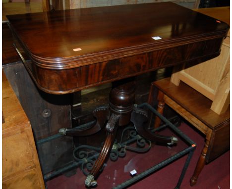 A William IV mahogany round cornered fold-over card table having a reeded edge, revolving action and raised on acanthus leaf 